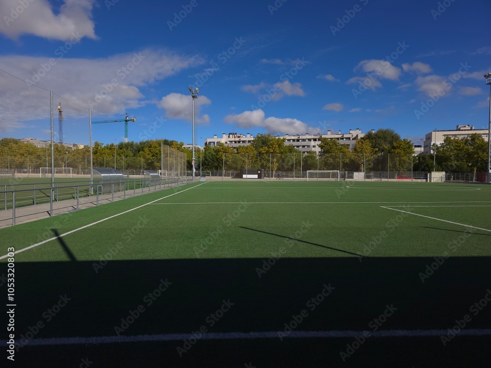 Fototapeta premium Sunlit Football Field with Clear Blue Skies