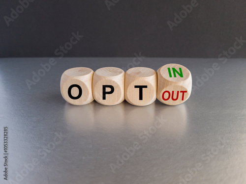 Turned a cube and changed concept words opt out to opt in. Beautiful grey table black background. Business concept.