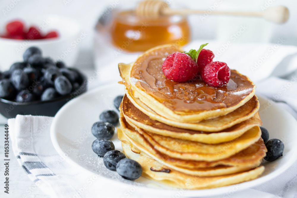 Pancakes with fresh berries and honey. on a wooden background. breakfast Pancakes with fresh berries and honey. on a wooden background. breakfast