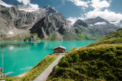 Beautiful alpine mountain scenery with traditional wooden mountain hut at Mooserboden high-mountain water reservoir lakes in Nationalpak Hohe Tauern, Salzburg Land, Austria