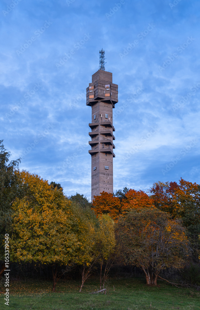 Obraz premium Concrete Radio Tower in Autumn Forest in the foreground