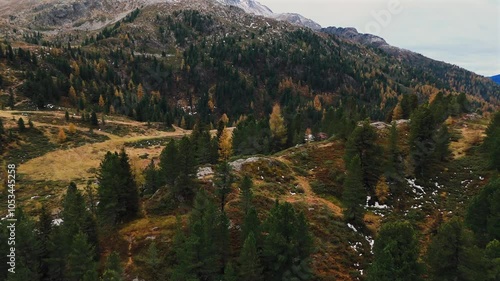 Aerial footage of the top of Staller Sattel, where cars are waiting for their turn to use the road. The autumn landscape at the Austria-Italy border features colorful trees and rugged mountain terrain photo