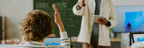 фотографія Student indicating eagerness to participate in classroom discussion by raising h