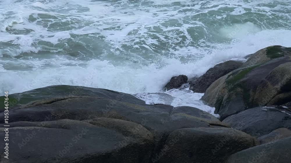 Dynamic waves crashing vigorously against rugged and steadfast rocks Dynamic waves crashing vigorously against rugged and steadfast rocks