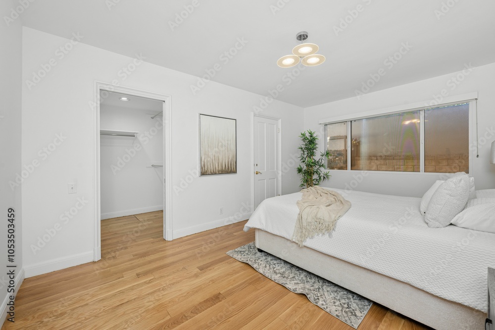 Fototapeta premium Modern minimalist bedroom with walk-in closet.