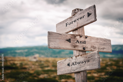 forever and always text quote written on wooden signpost at the crossroads outdoors in nature.