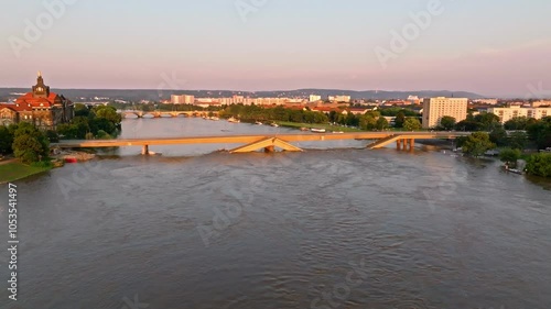 Drone video of Dresden during a flood with warm light highlighting the damaged Carola Bridge as the main focus. Drone move right photo