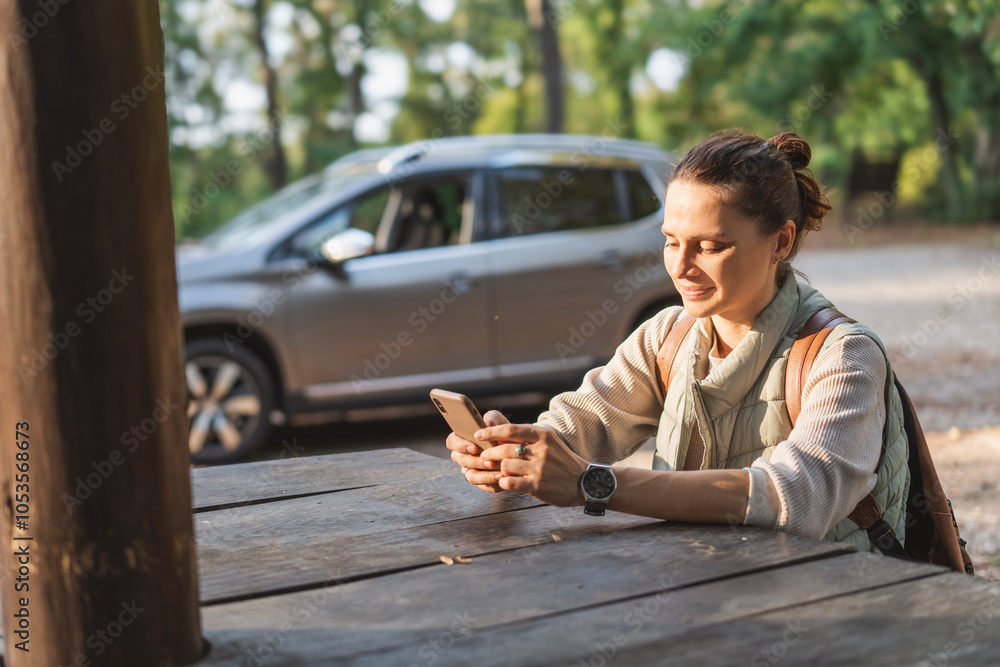 Female driver traveler sitting in rest area for drivers with phone in hands