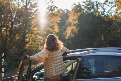 Happy woman driver traveling by car in forest enjoying freedom and nature photo