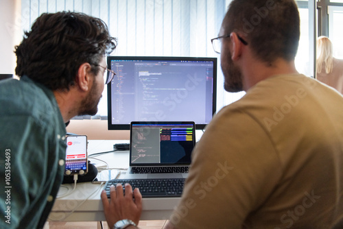 Programmers engrossed in deep collaboration, diligently working together to solve complex problems and develop innovative mobile applications with seamless functionality.