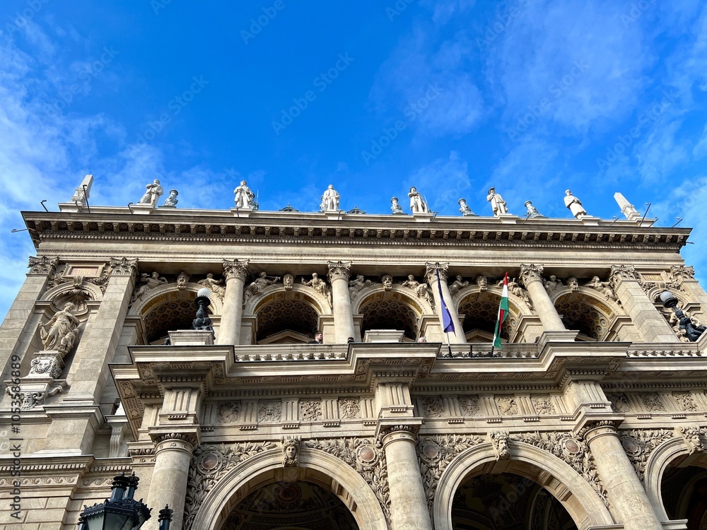 Obraz premium ornate facade of hungarian state opera house with statues under blue sky in budapest