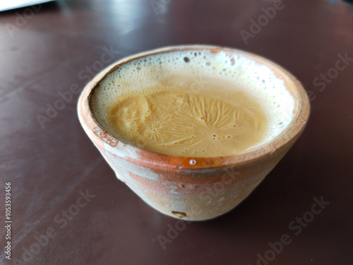 A kulhar or kulhad cup (traditional handle-less clay cup) from India filled with hot Indian tea. Indian desi cup for drinking tea photo