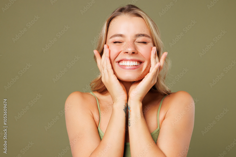 Close up young smiling happy nice lady woman with slim skinny body perfect skin wear top bra lingerie stand touch face close eyes isolated on plain pastel green background. Lifestyle diet fit concept. Close up young smiling happy nice lady woman with slim skinny body perfect skin wear top bra lingerie stand touch face close eyes isolated on plain pastel green background. Lifestyle diet fit concept.