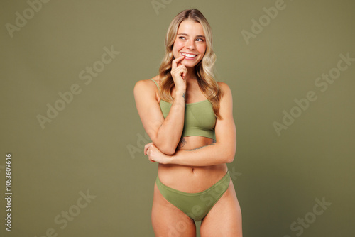 Young smiling happy nice lady woman with slim skinny body perfect skin fun wear top bra lingerie stand look aside on area mock up isolated on plain pastel green background. Lifestyle diet fit concept.