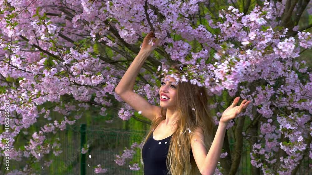 Gorgeous young woman in rose petals outdoor. Happy woman throwing spring blossom petals. Spring vibes. Nature portrait. Cherry petals falling on beauty woman. Girl throwing sakura flower petals. Gorgeous young woman in rose petals outdoor. Happy woman throwing spring blossom petals. Spring vibes. Nature portrait. Cherry petals falling on beauty woman. Girl throwing sakura flower petals.