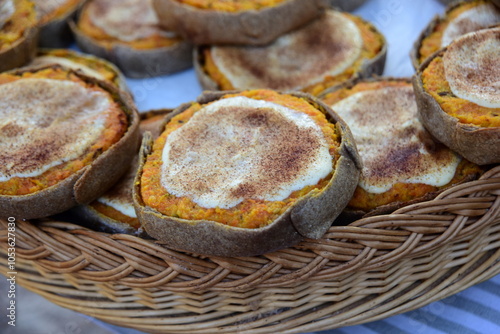 Rye tarte with carrot, potatoes and cumin in a wicker basket. Latvian dessert at Sklandrausis with carrot and rye dough photo