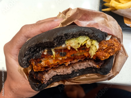 black hamburger in hand, Black hamburgers are eaten photo