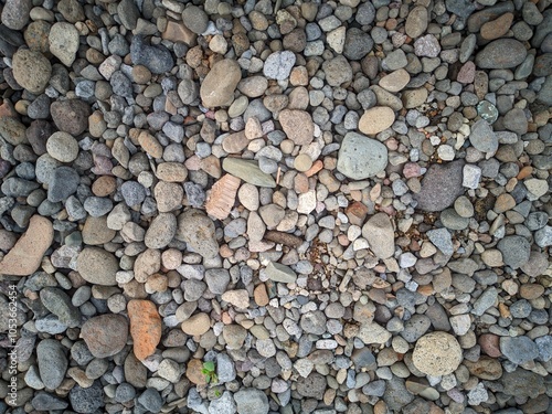 Background of smooth round pebble texture. Cover pebbles of various colors and patterns, gray pebbles, beige pebbles, reddish pebbles.  Gravel texture.