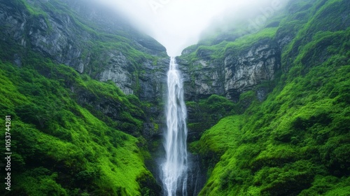A waterfall cascading down the side of a towering mountain, surrounded by moss-covered rocks and mist for International Mountain Day 