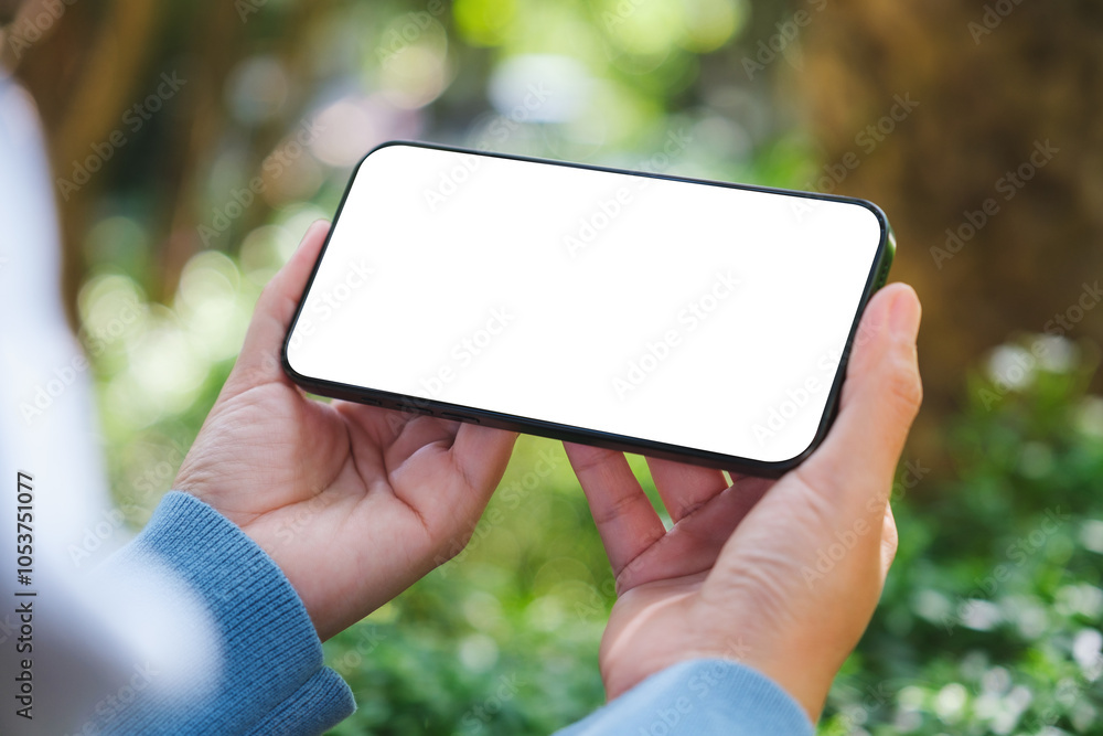 Mockup image of a woman holding mobile phone with blank white desktop screen in the outdoors Mockup image of a woman holding mobile phone with blank white desktop screen in the outdoors