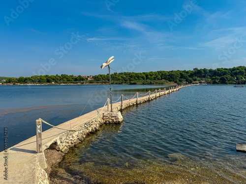 Fototapeta Naklejka Na Ścianę i Meble -  Scenic view of bridge Scuza Trockenmauer connecting coastal towns Pomer and Premantura, Istria peninsula, Croatia, Europe. Touristic biking road along the coastline of Kvarner Bay, Adiratic sea