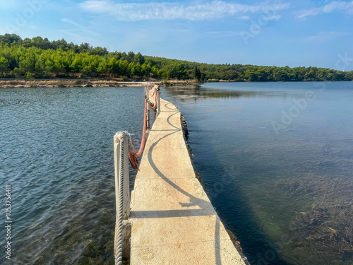 Scenic view of bridge Scuza Trockenmauer connecting coastal towns Pomer and Premantura, Istria peninsula, Croatia, Europe. Touristic biking road along the coastline of Kvarner Bay, Adiratic sea photo