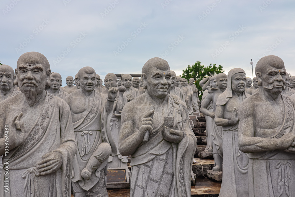Obraz premium Large group of statues of monks or religious figures arranged in rows in buddhist temple Patung Seribu (Vihara Ksitigarbha Bodhisattva, 500 Lohan Temple) on Bintan Island, Indonesia. Tanjung Pinang