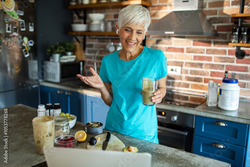 Senior woman preparing healthy smoothie in modern kitchen photo