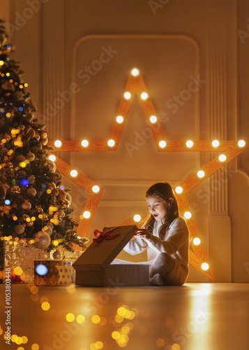 Happy girl opening christmas gift or new year presents. Children with gift boxes and christmas star. Decorated living room with traditional fire place. Poster. photo