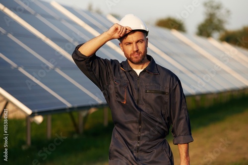 Handsome guy portrait. Man is working with solar panels outdoors at daytime photo