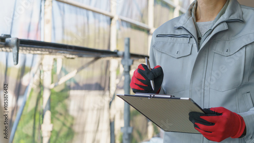 修繕工事の足場の点検をする作業服の男性