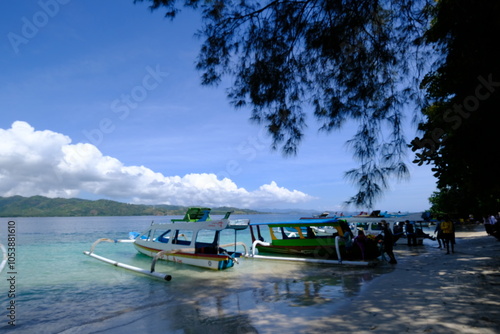 blue jukung boat in tropical waters. clear blue sky. small tropical island. photo