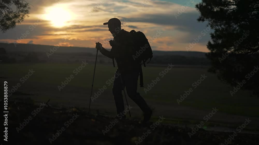 Silhouette of man walking with backpack on trail. Peaceful hike through nature at sunset. Traveler with backpack enjoys scenic trail walk. Silhouette adventure walking with backpack on outdoor trail Silhouette of man walking with backpack on trail. Peaceful hike through nature at sunset. Traveler with backpack enjoys scenic trail walk. Silhouette adventure walking with backpack on outdoor trail