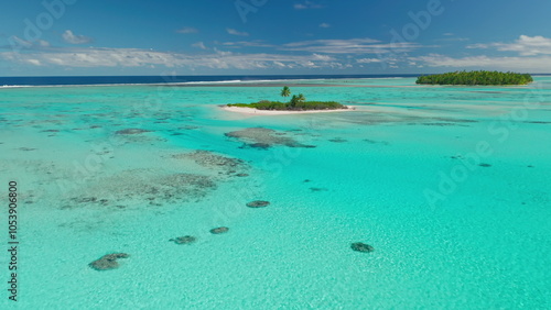 Aerial view of a tiny tropical French Polynesia island surrounded by vast ocean waters.