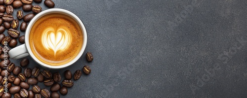A cup of coffee with heart shaped latte art and coffee beans.