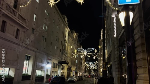 A magical view of Regent Street's iconic Christmas lights in London, UK. Shimmering decorations brighten the bustling street, capturing the holiday spirit with festive sparkle and charm.