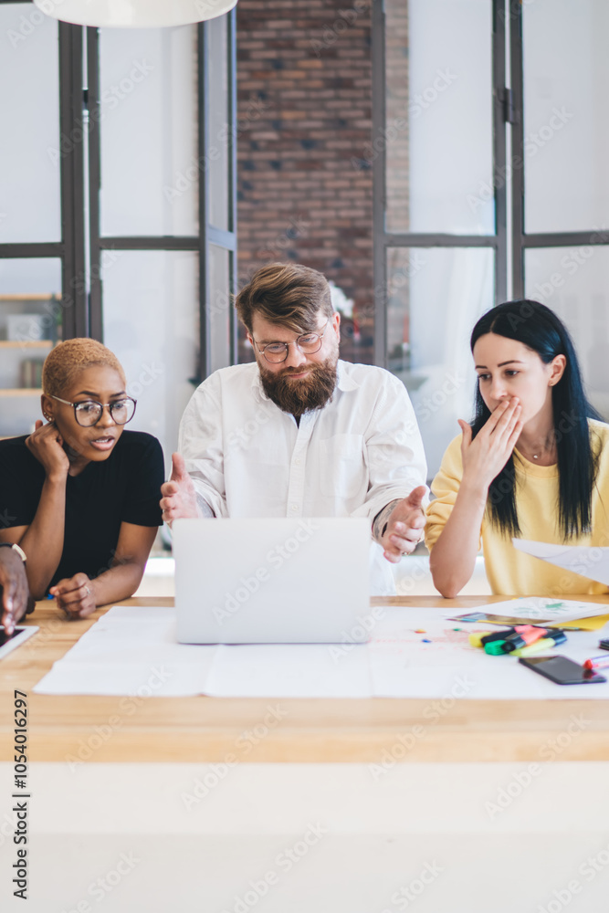 Fototapeta premium Group of shocked multiethnic coworkers using laptop at office