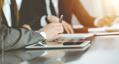 Unknown businessmen and woman sitting, working and discussing questions at meeting in sunny office, close-up. Success concept