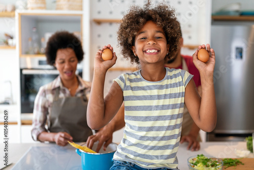 Happy african american parents and child having fun preparing healthy food in kitchen photo