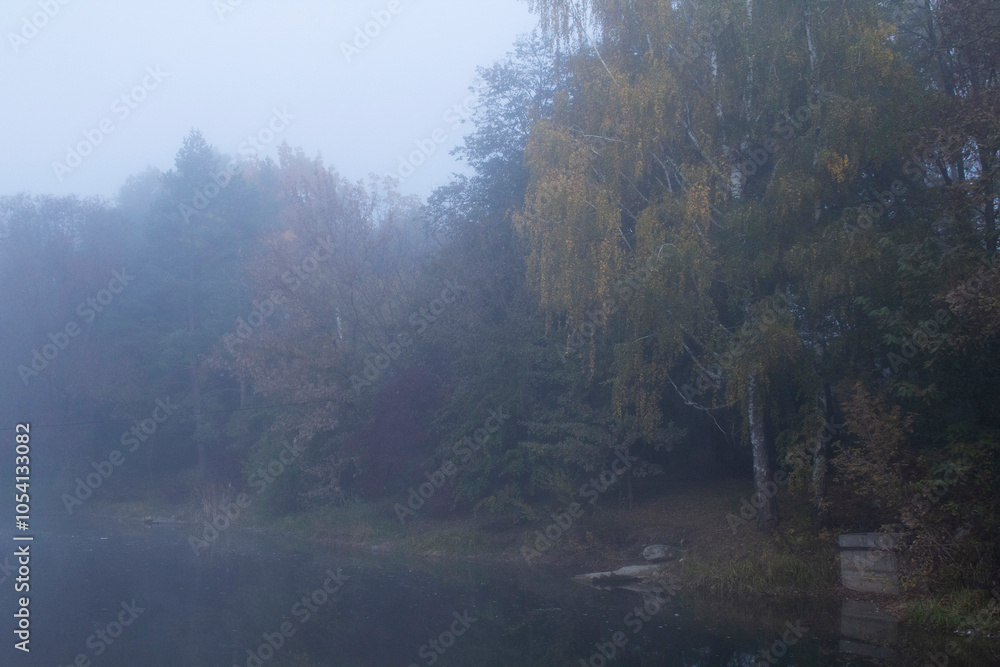 Autumn in Moldova, foggy landscape in the park. Thick fog early in the morning on the lake shore.
