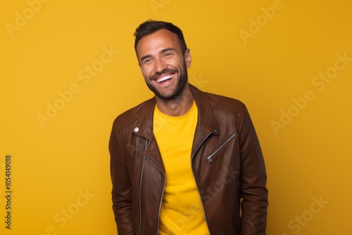 Portrait of a cheerful man in his 30s wearing a trendy bomber jacket on solid color backdrop