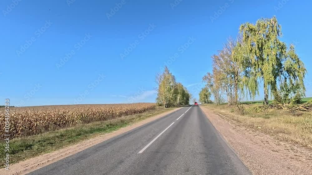 The car drives along the road on a autumn day. Highways, roadside and road line markings. The car drives along the road on a autumn day. Highways, roadside and road line markings.