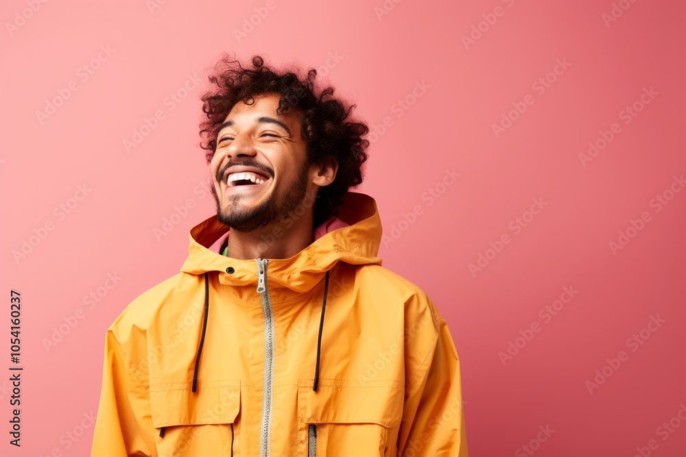 Fototapeta premium Portrait of a joyful man in his 20s wearing a lightweight packable anorak isolated on solid color backdrop