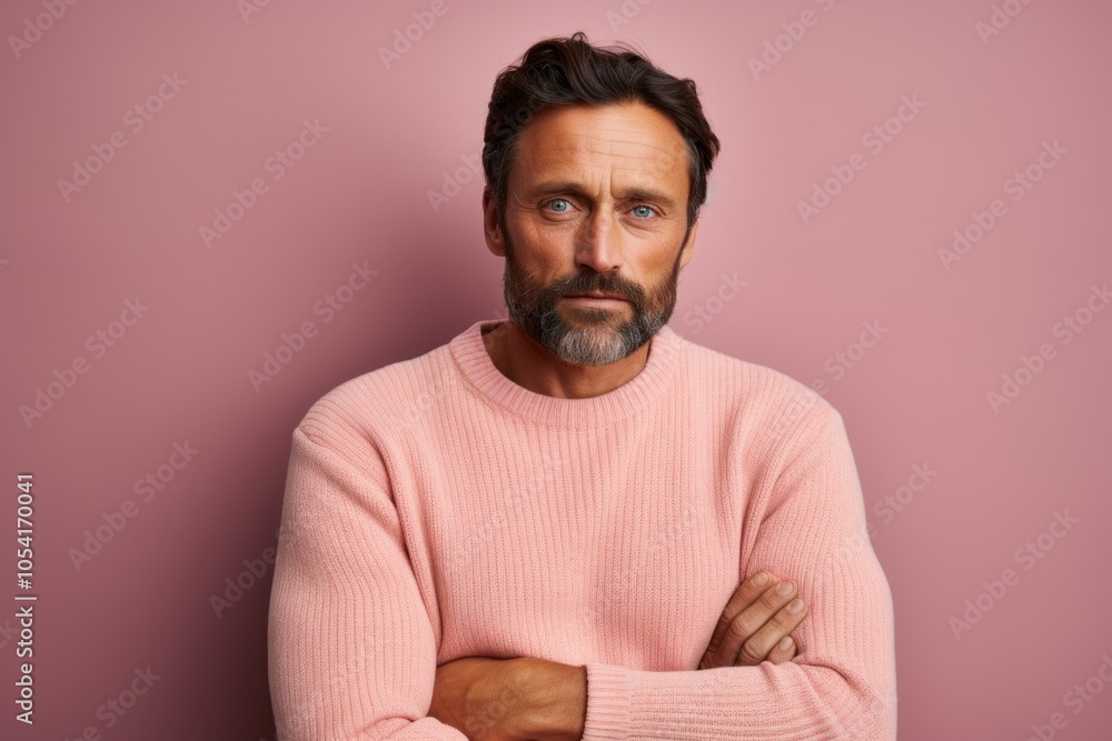 Obraz premium Portrait of a content man in his 40s dressed in a warm wool sweater on solid pastel color wall