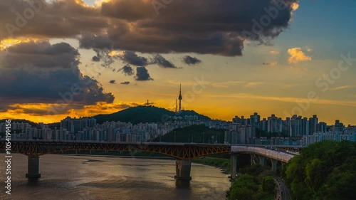 TimeLapse 4k (Zoom out)Seoul City after sunset and a sightseeing boat on the Han River and a bridge with Namsan Mountain and Seoul Tower in the background, Seoul, South Korea.