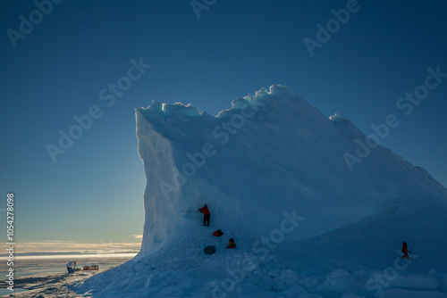 Explorers Climbing Majestic Iceberg at Pond Inlet