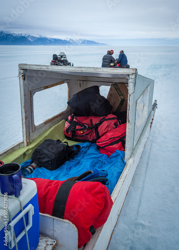 Snowmobile Adventure Over Frozen Lake in Arctic Landscape
