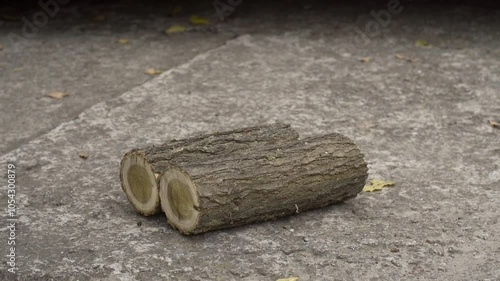 Stacked wooden logs for kindling the stove, which the hand picks up.