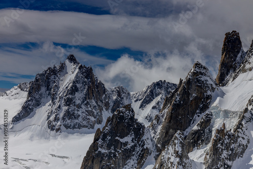 Snow covered mountains and rocky peaks of the Alps from the sky way between Chamonix and Courmayeur in Italy and France Alps. Dent du Gigante rocky towering peak and glacier at the bottom of Montblanc