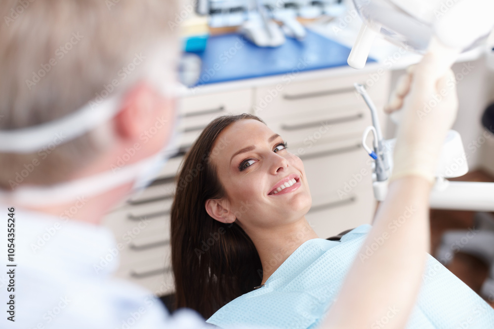Obraz premium Clinic, happy and dentist with woman for consulting, teeth whitening and oral health on chair. Healthcare, dentistry and man with patient with tools for dental hygiene, cleaning and medical service